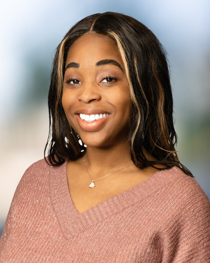 Black fem-presenting person with streaked shoulder-length hair